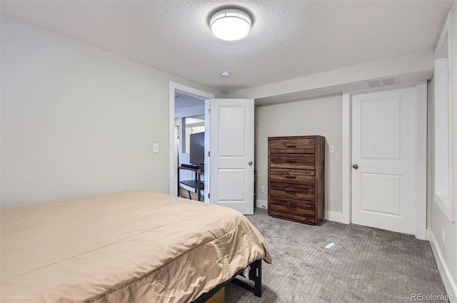 carpeted bedroom with a textured ceiling