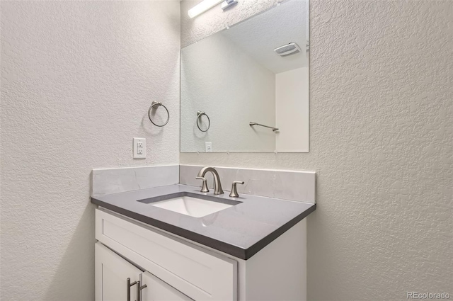 bathroom with a textured ceiling and vanity