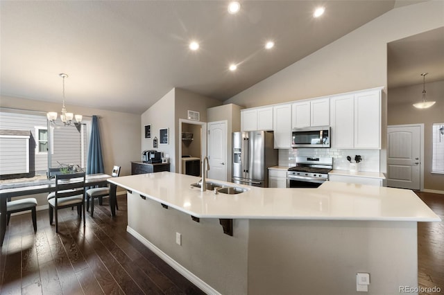 kitchen featuring a spacious island, pendant lighting, appliances with stainless steel finishes, sink, and backsplash