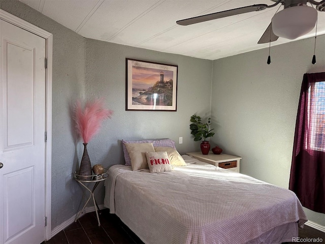 bedroom with dark hardwood / wood-style flooring and ceiling fan