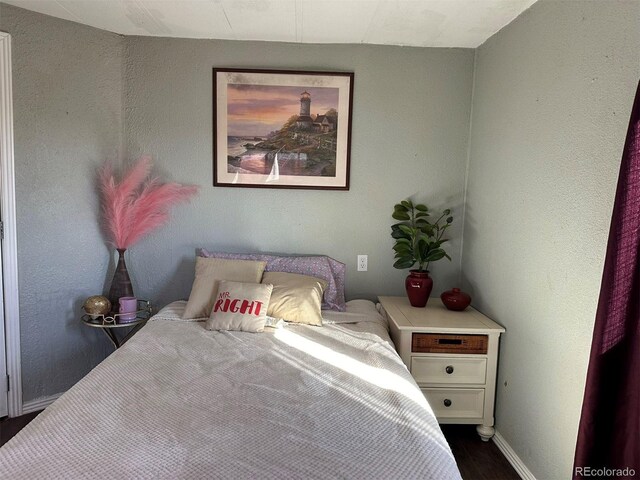 bedroom with dark hardwood / wood-style flooring