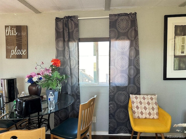 dining space featuring beamed ceiling