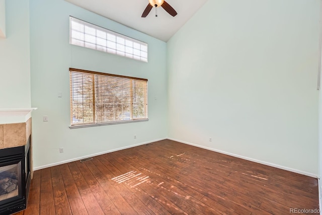 unfurnished living room with a fireplace, ceiling fan, dark hardwood / wood-style flooring, and high vaulted ceiling