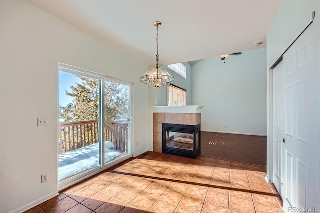 unfurnished living room with a chandelier, light tile patterned floors, and a tiled fireplace