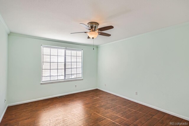 empty room with ornamental molding, ceiling fan, and dark wood-type flooring