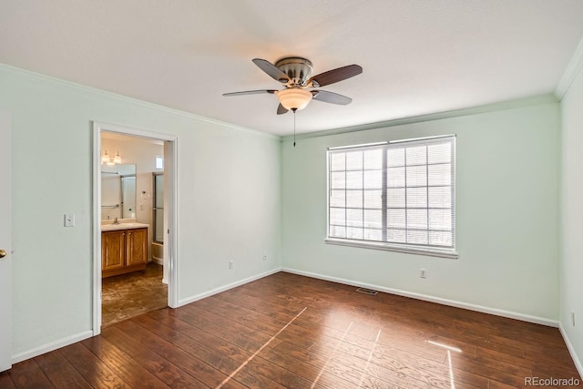 empty room with crown molding, dark hardwood / wood-style flooring, ceiling fan, and sink