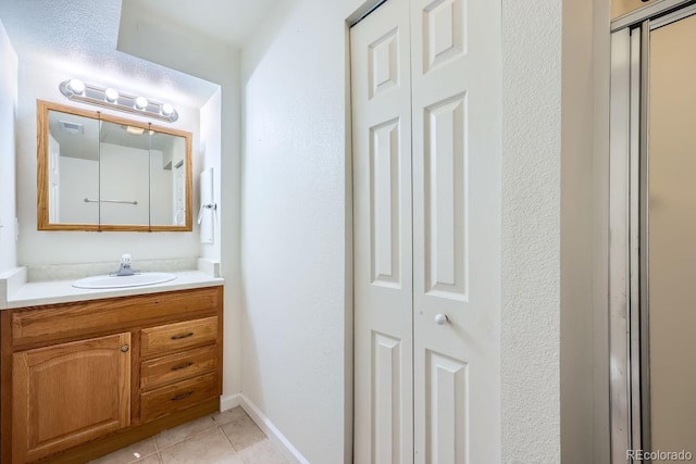 bathroom featuring vanity, tile patterned floors, and an enclosed shower