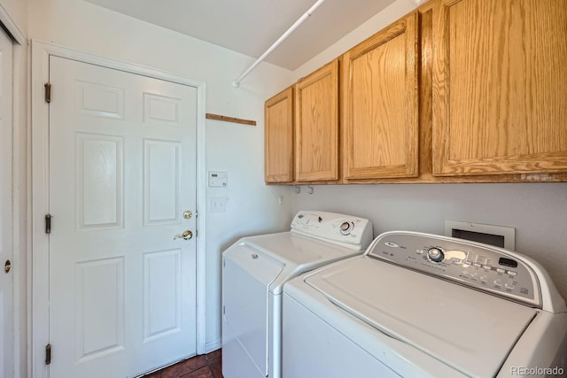 washroom featuring cabinets and washer and clothes dryer