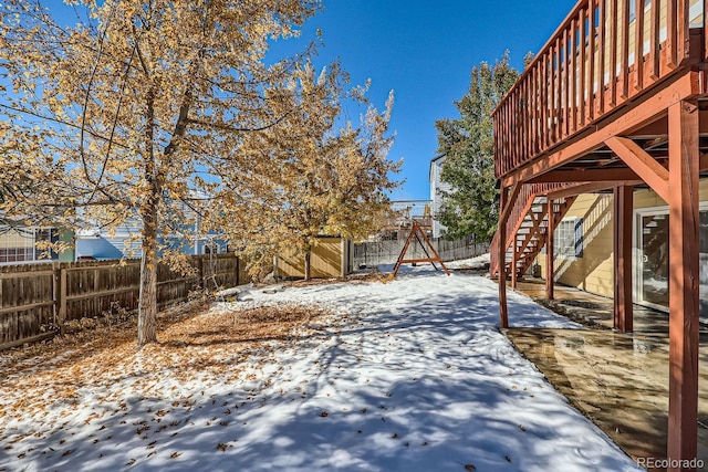 yard layered in snow with a deck