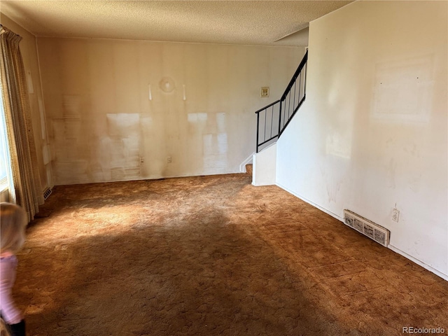 8779 Santa Fe Dr, Thornton, CO 80260 - unfurnished room featuring carpet, stairs, and a textured ceiling