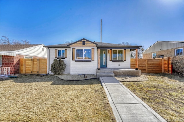 bungalow-style home with covered porch, fence, and brick siding