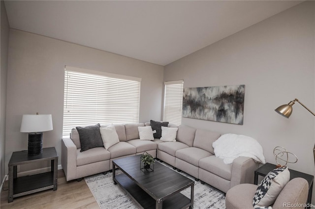 living area featuring vaulted ceiling and light wood-style flooring