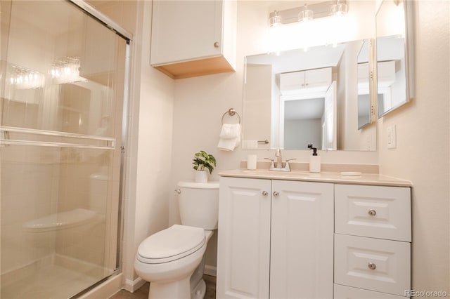 bathroom with toilet, a stall shower, and vanity