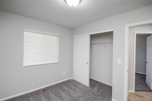 unfurnished bedroom featuring carpet flooring, a closet, visible vents, and baseboards