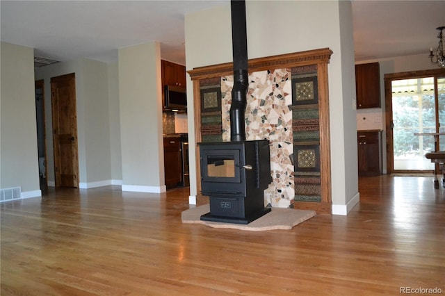 unfurnished living room with light hardwood / wood-style floors and a wood stove