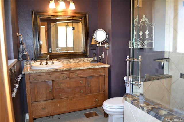 bathroom with tile patterned flooring, vanity, and toilet