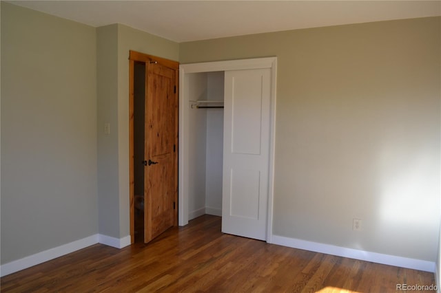 unfurnished bedroom featuring dark hardwood / wood-style flooring and a closet