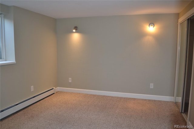 carpeted spare room with a baseboard radiator