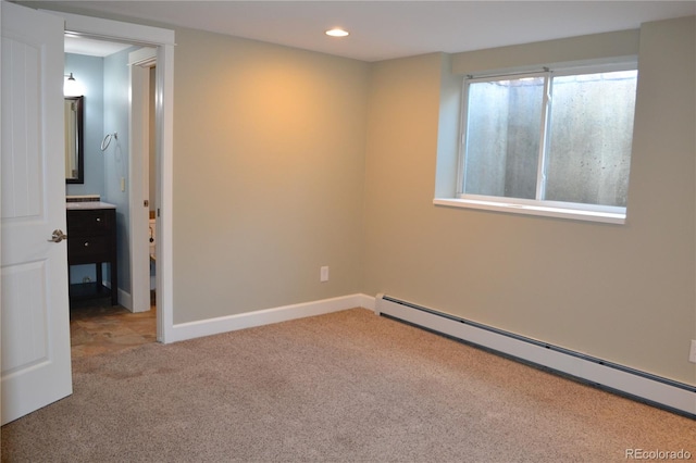 empty room featuring light carpet and a baseboard heating unit