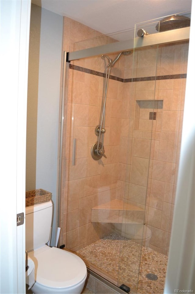 bathroom featuring toilet and an enclosed shower