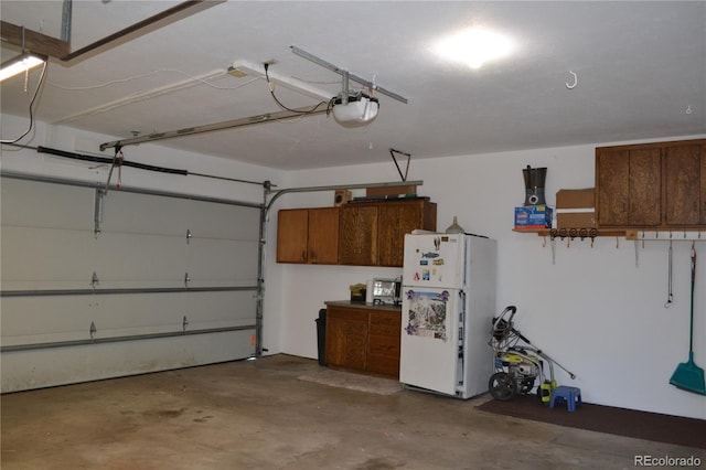 garage with white fridge and a garage door opener