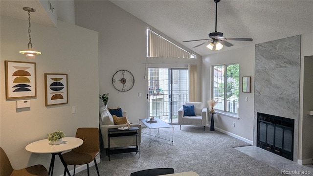 13854 E Lehigh Ave Unit D, Aurora, CO 80014 - carpeted living area featuring a ceiling fan, a textured ceiling, baseboards, a premium fireplace, and high vaulted ceiling