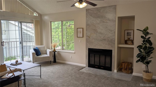 13854 E Lehigh Ave Unit D, Aurora, CO 80014 - carpeted living area featuring a ceiling fan, a textured ceiling, vaulted ceiling, a fireplace, and baseboards
