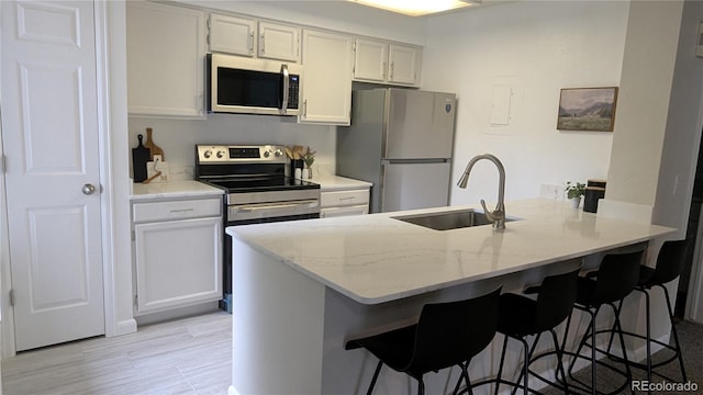 13854 E Lehigh Ave Unit D, Aurora, CO 80014 - kitchen featuring stainless steel appliances, a sink, a peninsula, and a kitchen breakfast bar