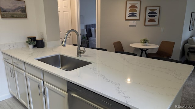 13854 E Lehigh Ave Unit D, Aurora, CO 80014 - kitchen with a sink, stainless steel dishwasher, light stone countertops, and white cabinetry