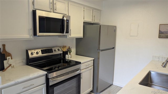 13854 E Lehigh Ave Unit D, Aurora, CO 80014 - kitchen featuring stainless steel appliances, a sink, light stone countertops, and light wood finished floors