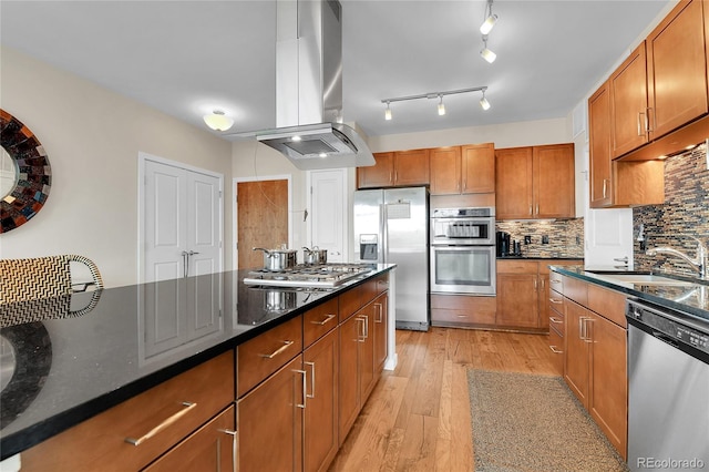 13598 Via Varra Unit 301, Broomfield, CO 80020 - kitchen featuring appliances with stainless steel finishes, island range hood, and brown cabinetry