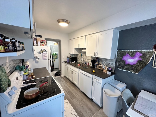 kitchen with white appliances, hardwood / wood-style flooring, white cabinetry, and sink