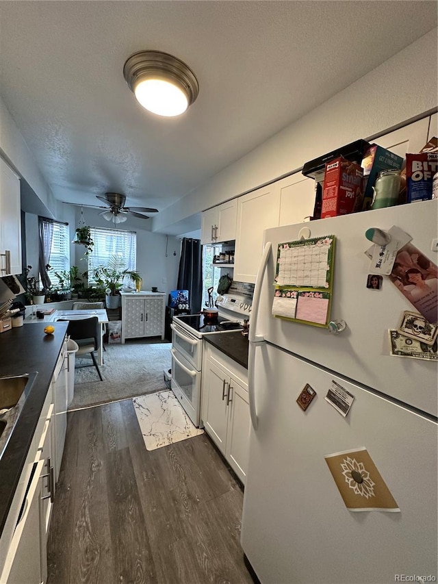 kitchen with white cabinets, ceiling fan, white appliances, and dark wood-type flooring