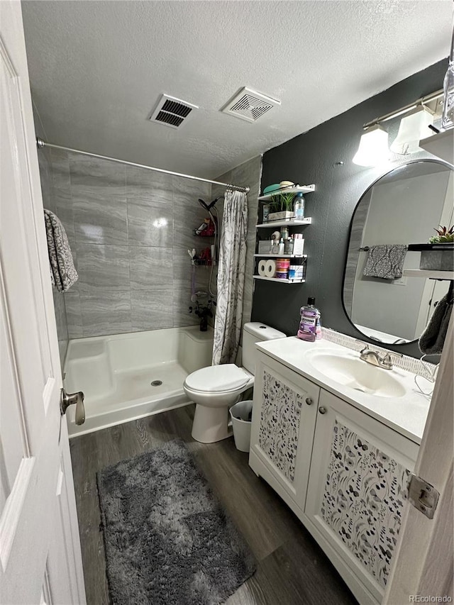 bathroom featuring vanity, a shower with shower curtain, toilet, a textured ceiling, and wood-type flooring