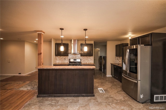 200 Garrison St, Lakewood, CO 80226 - kitchen featuring appliances with stainless steel finishes, wall chimney exhaust hood, backsplash, independent washer and dryer, and decorative light fixtures