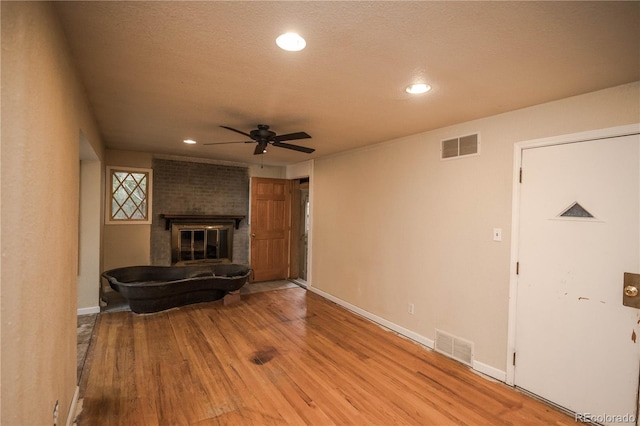 200 Garrison St, Lakewood, CO 80226 - unfurnished living room featuring a ceiling fan, wood finished floors, recessed lighting, a brick fireplace, and a textured ceiling