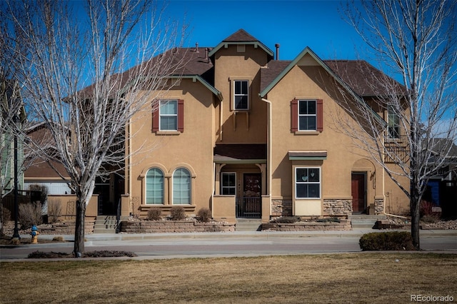 view of front of home featuring stone siding and stucco siding