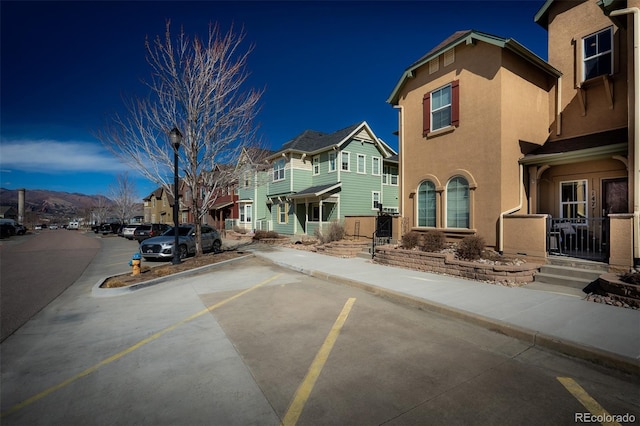 view of road with a residential view, curbs, sidewalks, and street lights