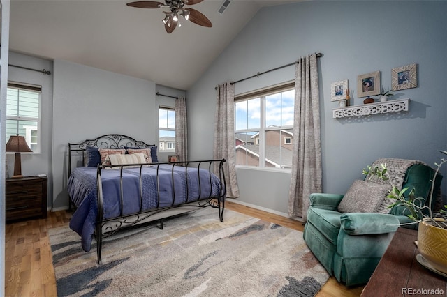 bedroom with lofted ceiling, wood finished floors, visible vents, and baseboards