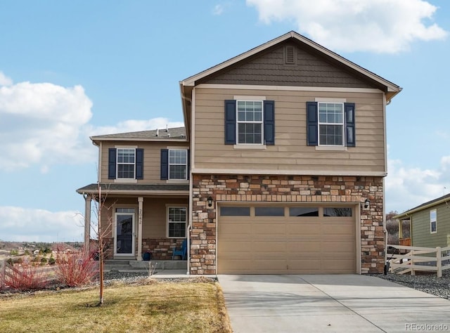 view of front of house featuring fence, concrete driveway, a front yard, stone siding, and an attached garage