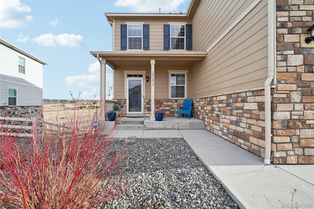 entrance to property with stone siding and covered porch