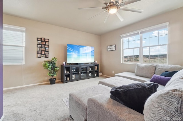 carpeted living room featuring baseboards and a ceiling fan