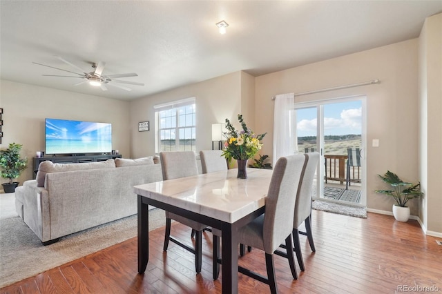 dining space featuring baseboards, ceiling fan, and hardwood / wood-style flooring