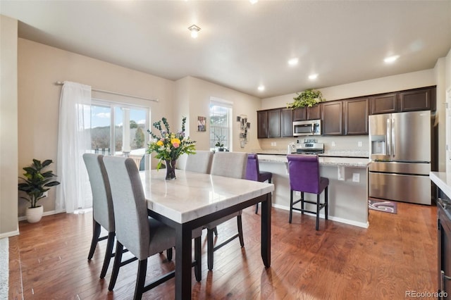 dining room with recessed lighting, baseboards, and wood finished floors