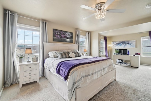 bedroom with multiple windows, light carpet, and a ceiling fan