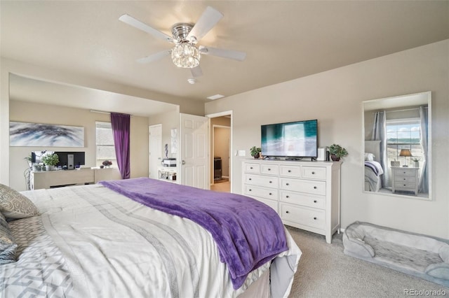 bedroom with light colored carpet, a ceiling fan, and multiple windows