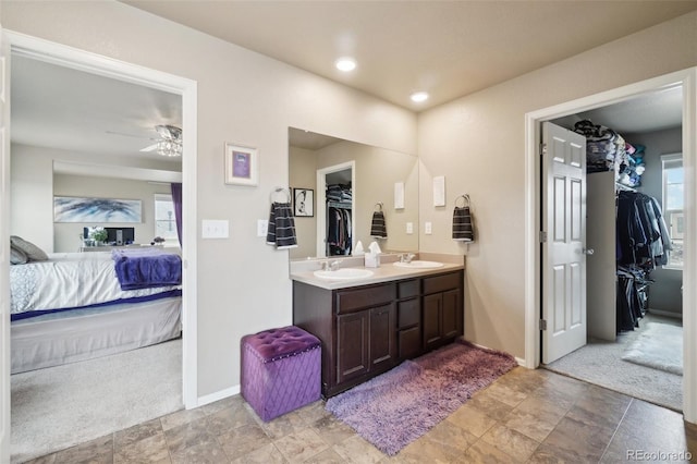 full bathroom featuring double vanity, a spacious closet, ensuite bathroom, and a sink