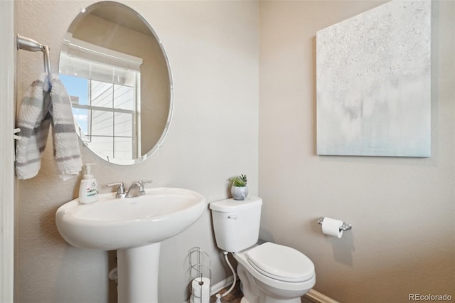 bathroom featuring baseboards and toilet