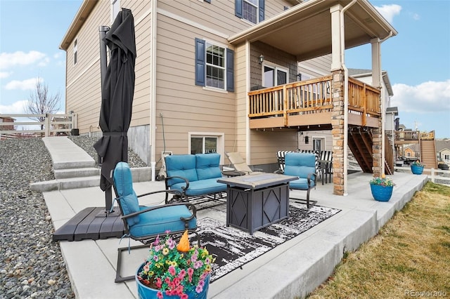 view of patio featuring an outdoor living space with a fire pit, a deck, and stairs