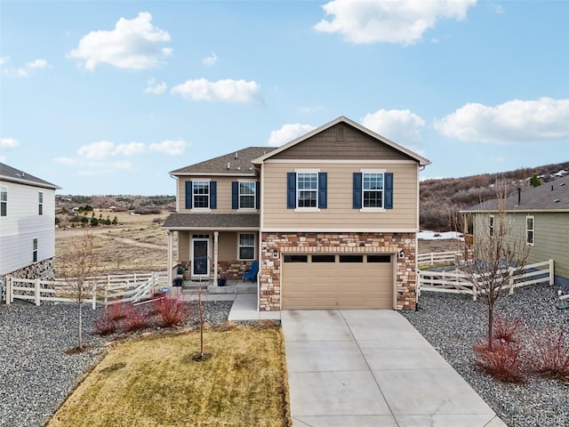 view of front facade featuring fence, an attached garage, a shingled roof, concrete driveway, and stone siding